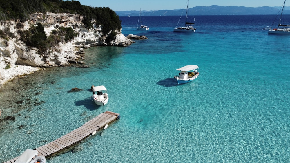 white and blue boat on blue sea water during daytime