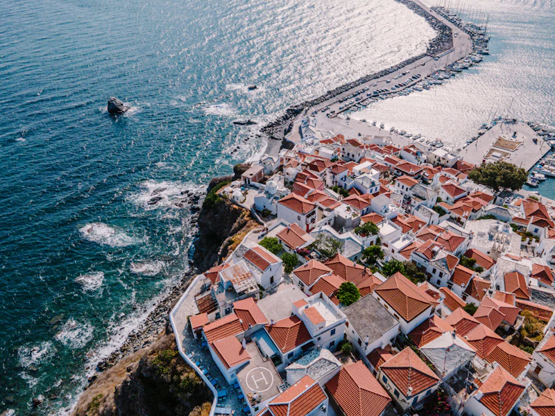 Aerial view of Skopelos town’s terracotta roofs beside the harbour wall