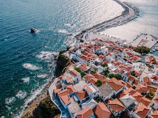 Aerial view of city buildings near body of water during daytime — Skopelos, Greece