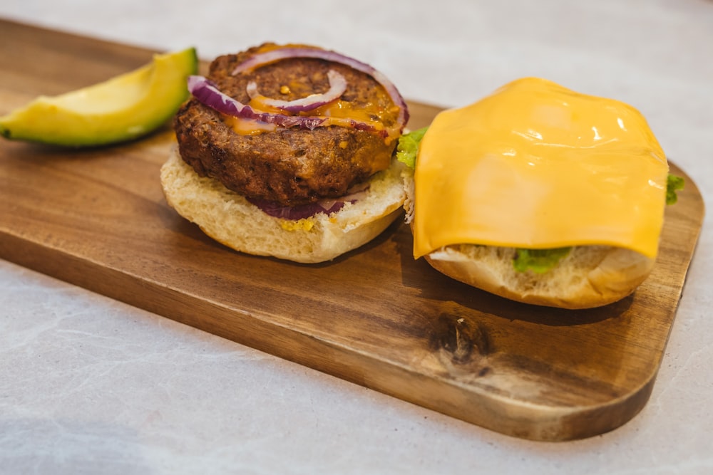 burger with lettuce and cheese on brown wooden chopping board