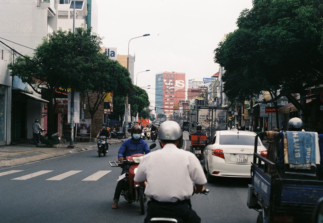 man in white shirt riding motorcycle on road during daytime