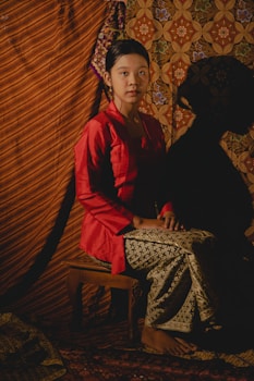 a woman in a red dress sitting on a chair