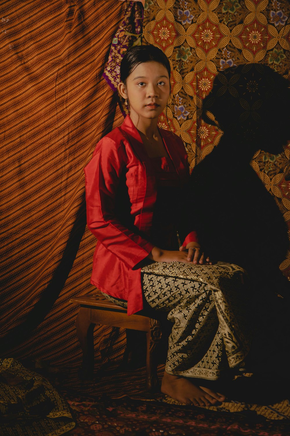 a woman in a red dress sitting on a chair