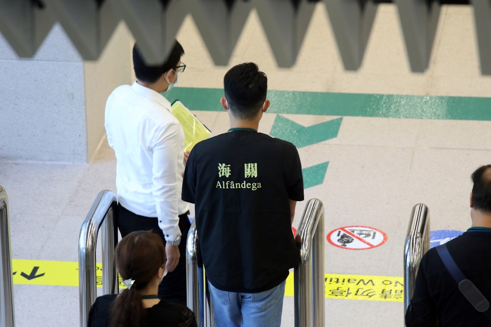 man in black crew neck t-shirt standing beside man in white t-shirt