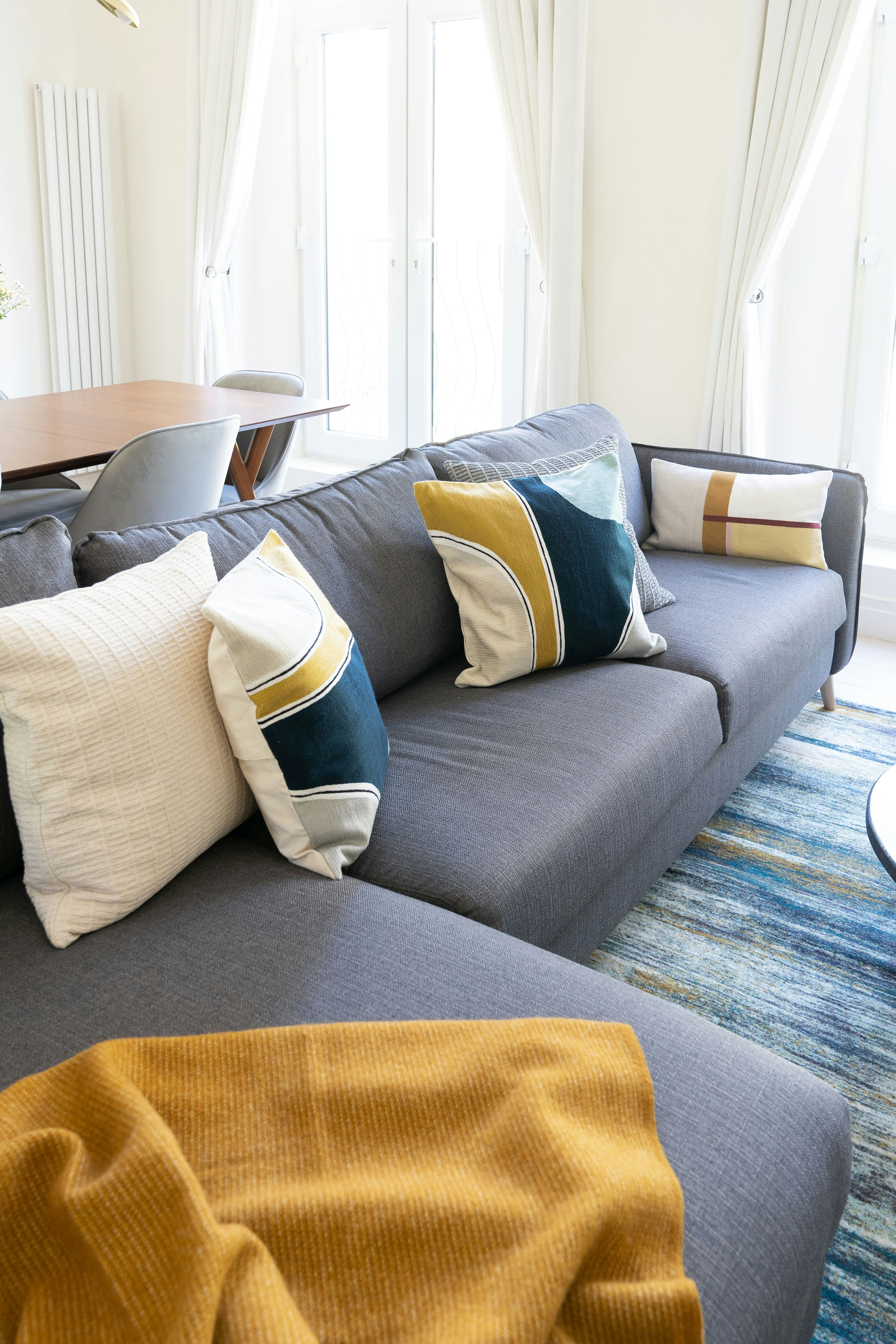 blue and white throw pillows on gray couch