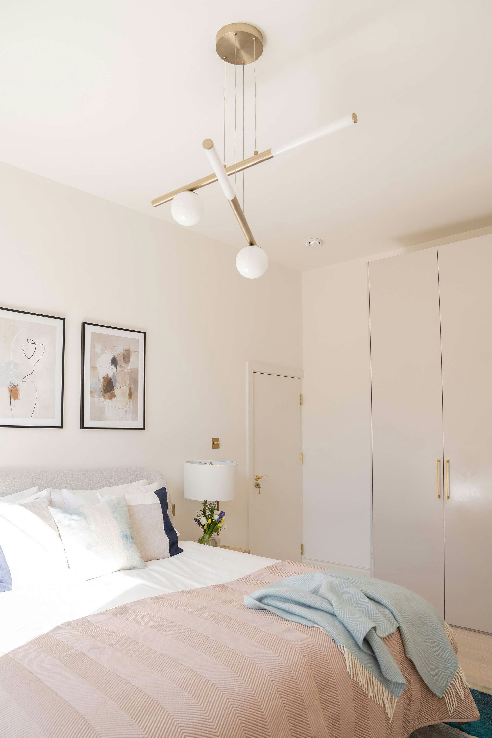 white bed linen near white wooden cabinet