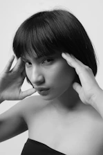 topless woman with left hand on her face