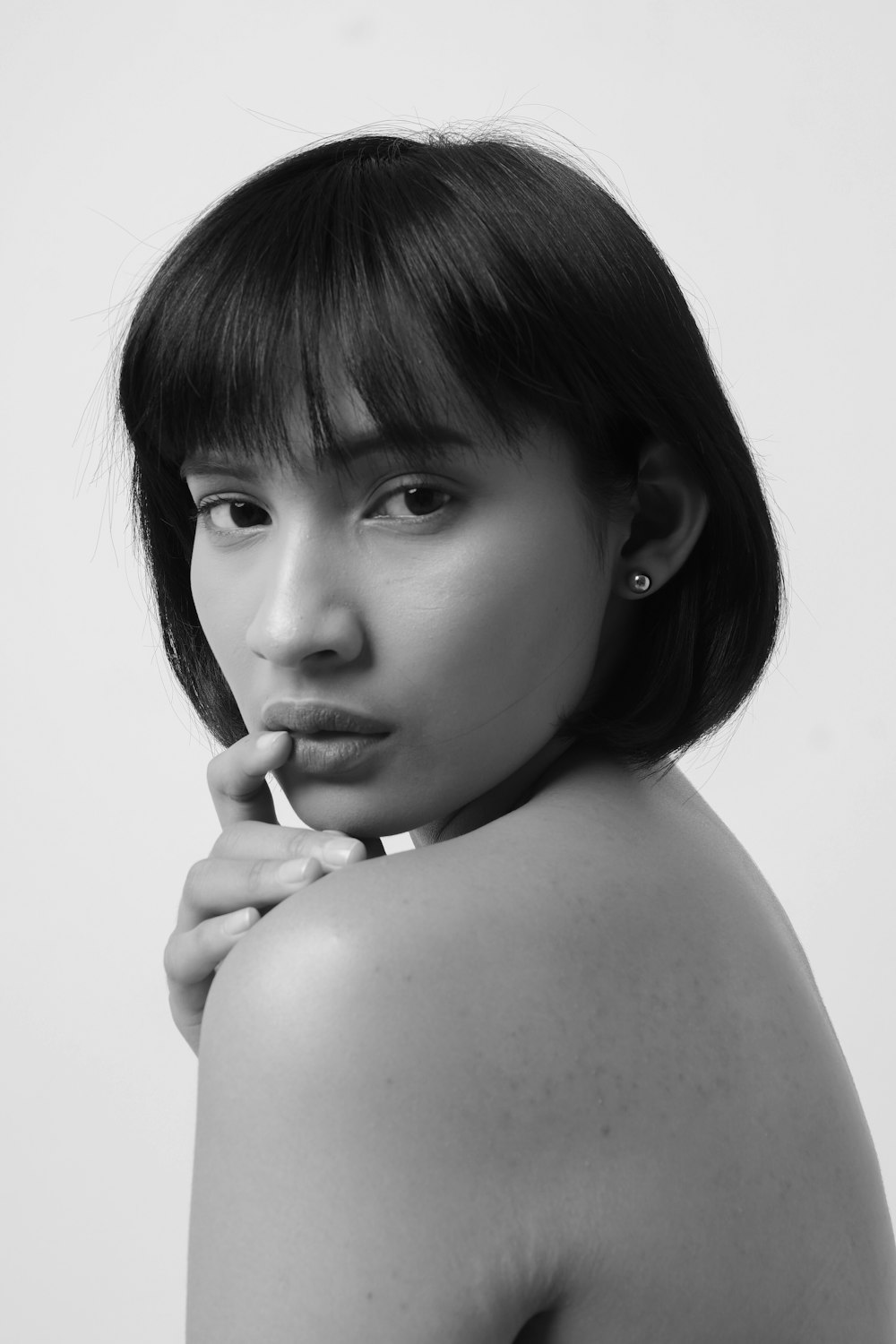 grayscale photo of woman with her hand on her chin