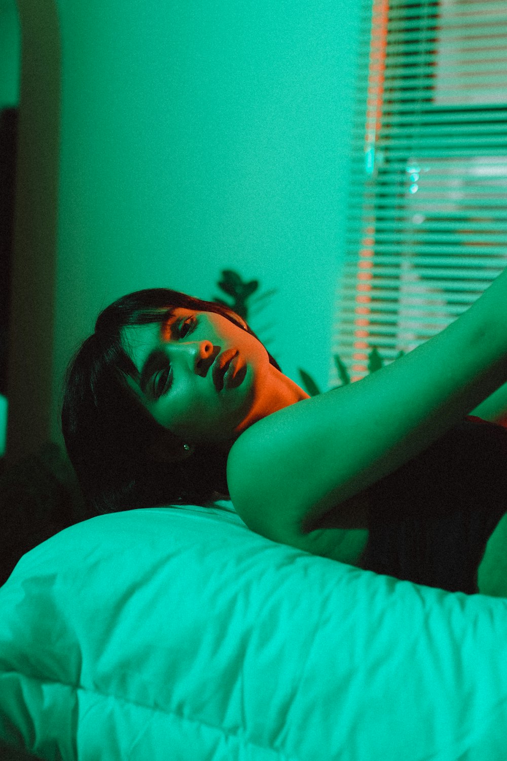 woman in black tank top lying on bed