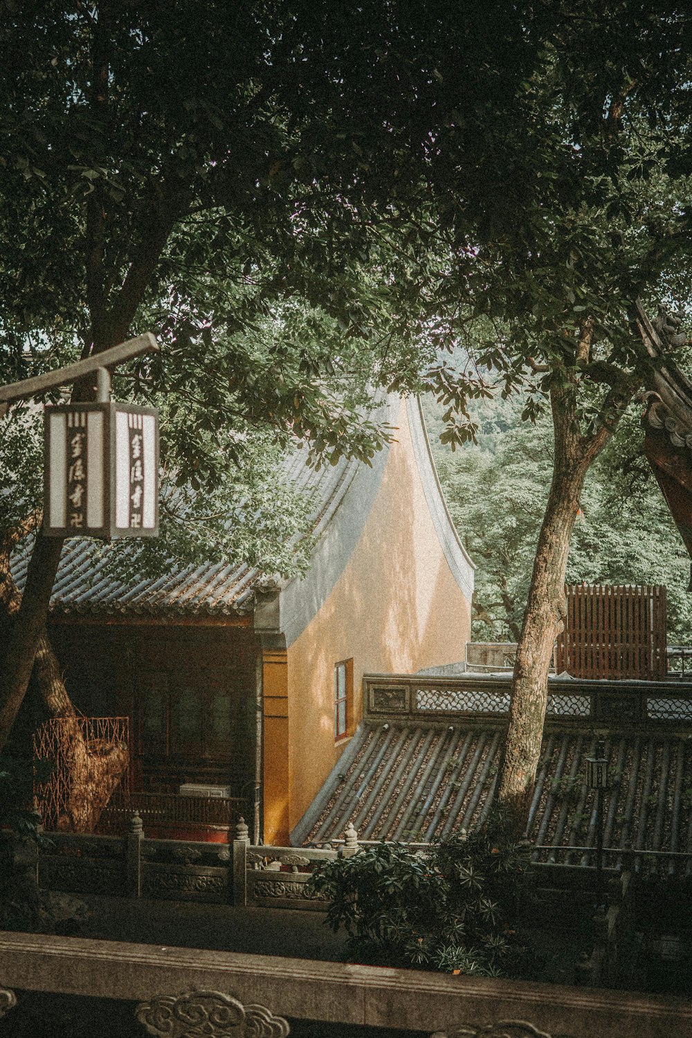 brown brick house near green trees during daytime