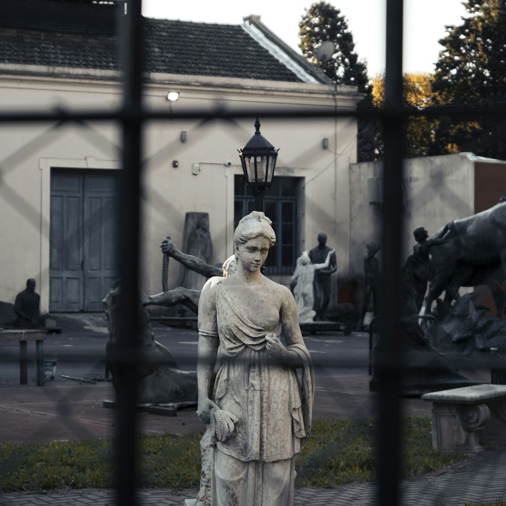 woman in dress statue near building during daytime