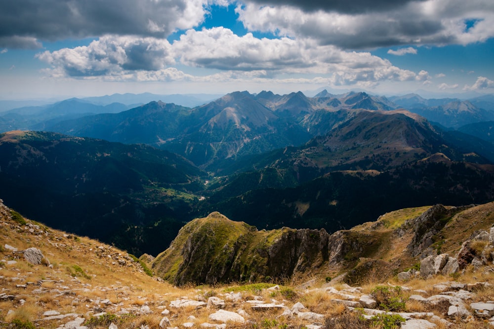 green and brown mountains under white clouds and blue sky during daytime