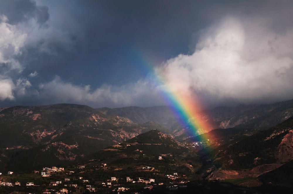 rainbow over rocky mountain during daytime