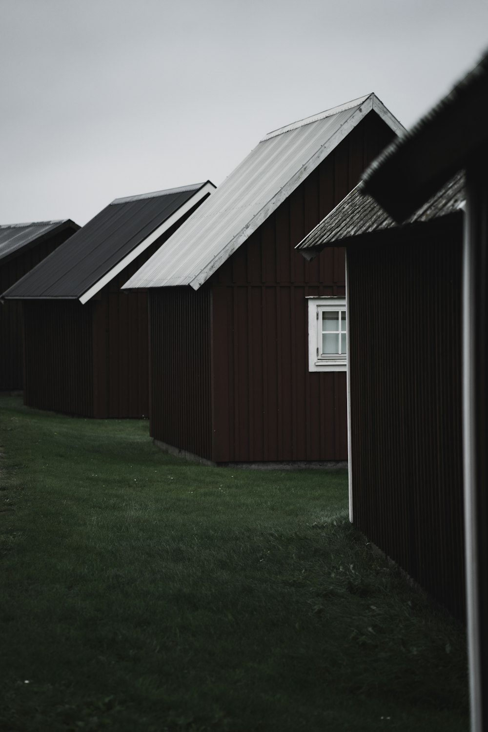 brown wooden house on green grass field during daytime