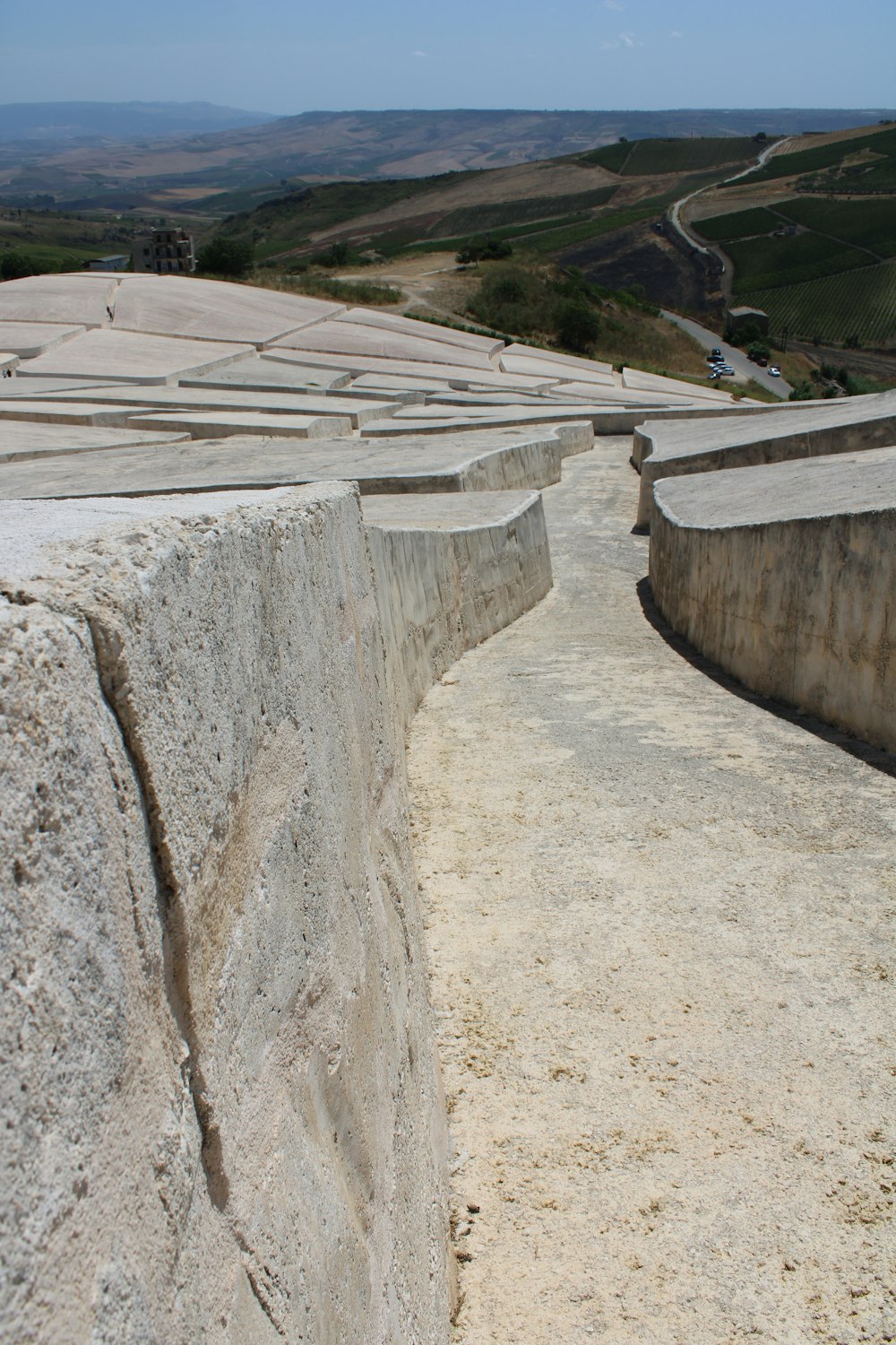 muro di cemento grigio vicino al campo di erba verde durante il giorno