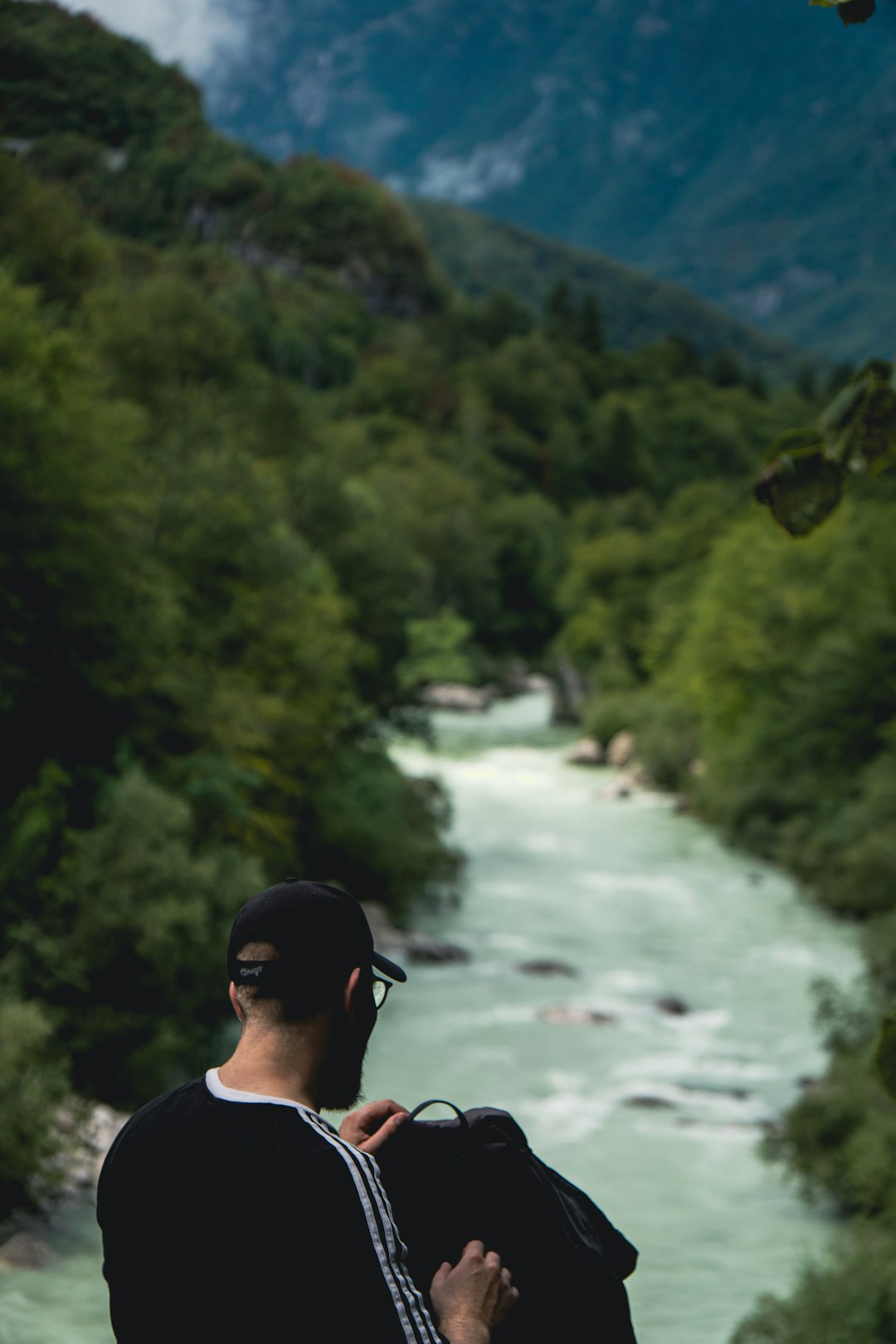man in black sunglasses and black cap standing on river during daytime