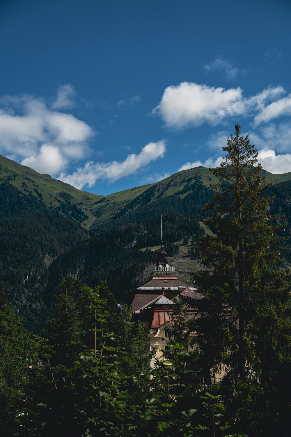 casa marrom e branca no topo da montanha sob o céu azul durante o dia