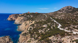 green and brown mountain beside blue sea under blue sky during daytime