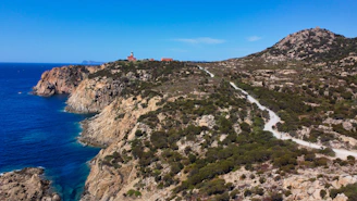 green and brown mountain beside blue sea under blue sky during daytime