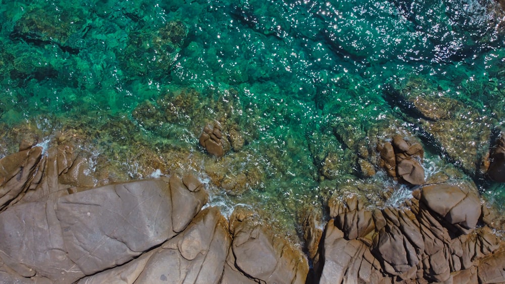 brown rock formation beside body of water during daytime