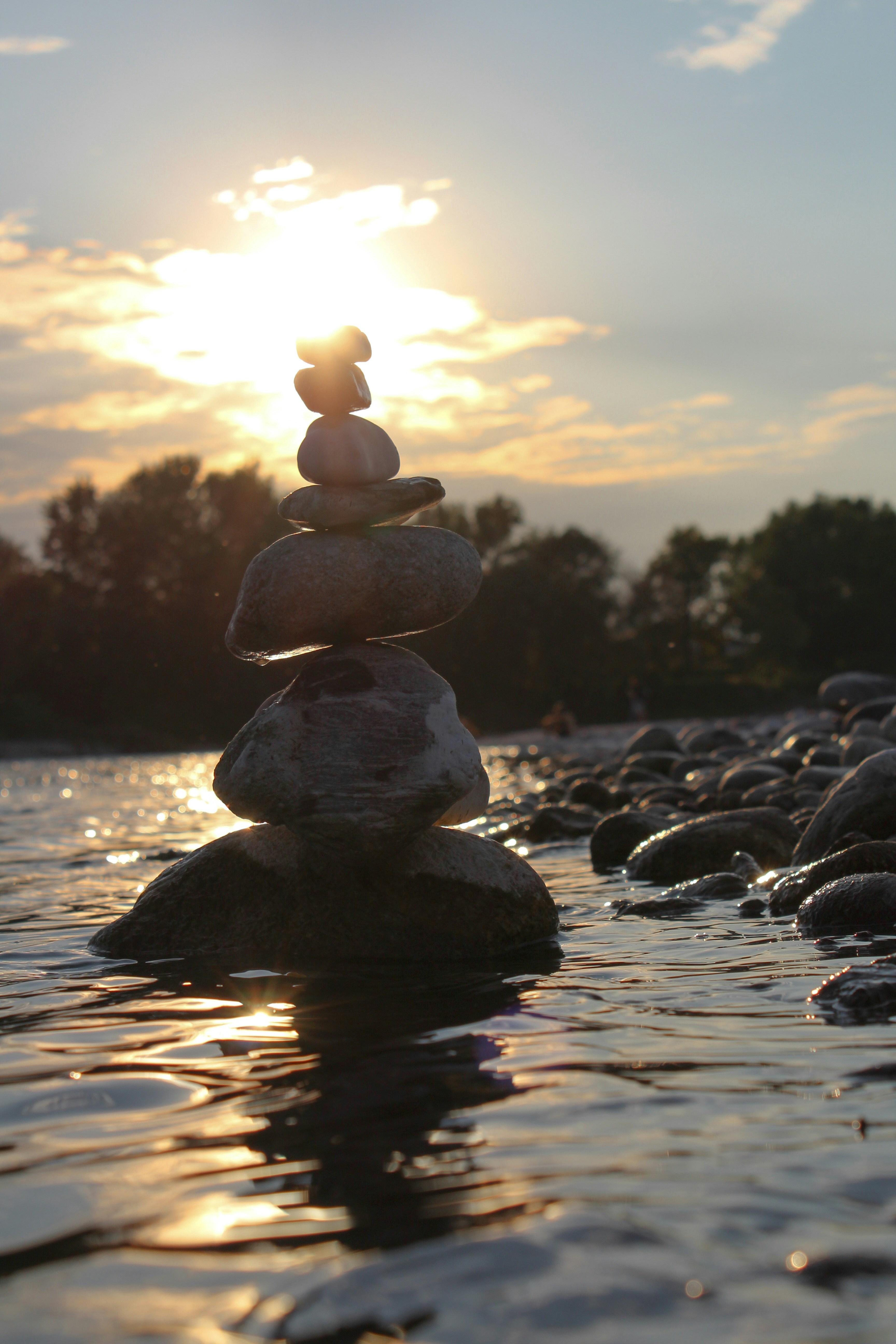 gray stone on water during sunset