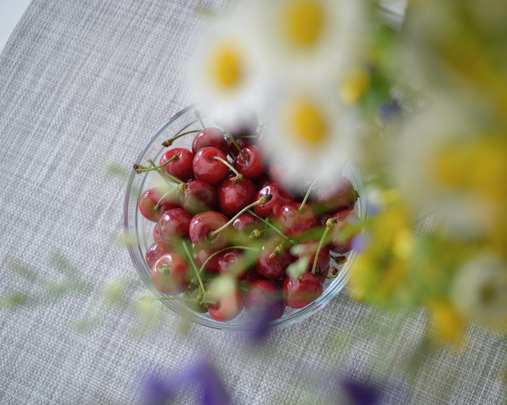 red and white round fruits on clear glass bowl