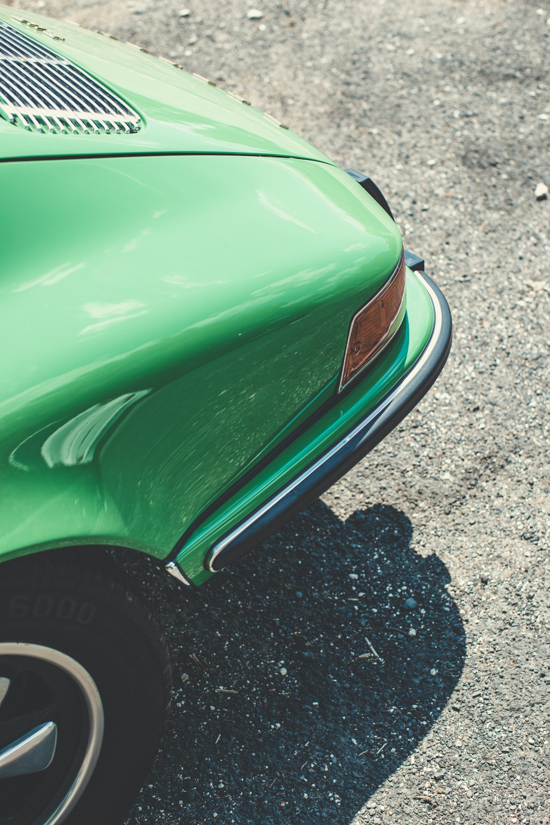 green car on gray asphalt road during daytime