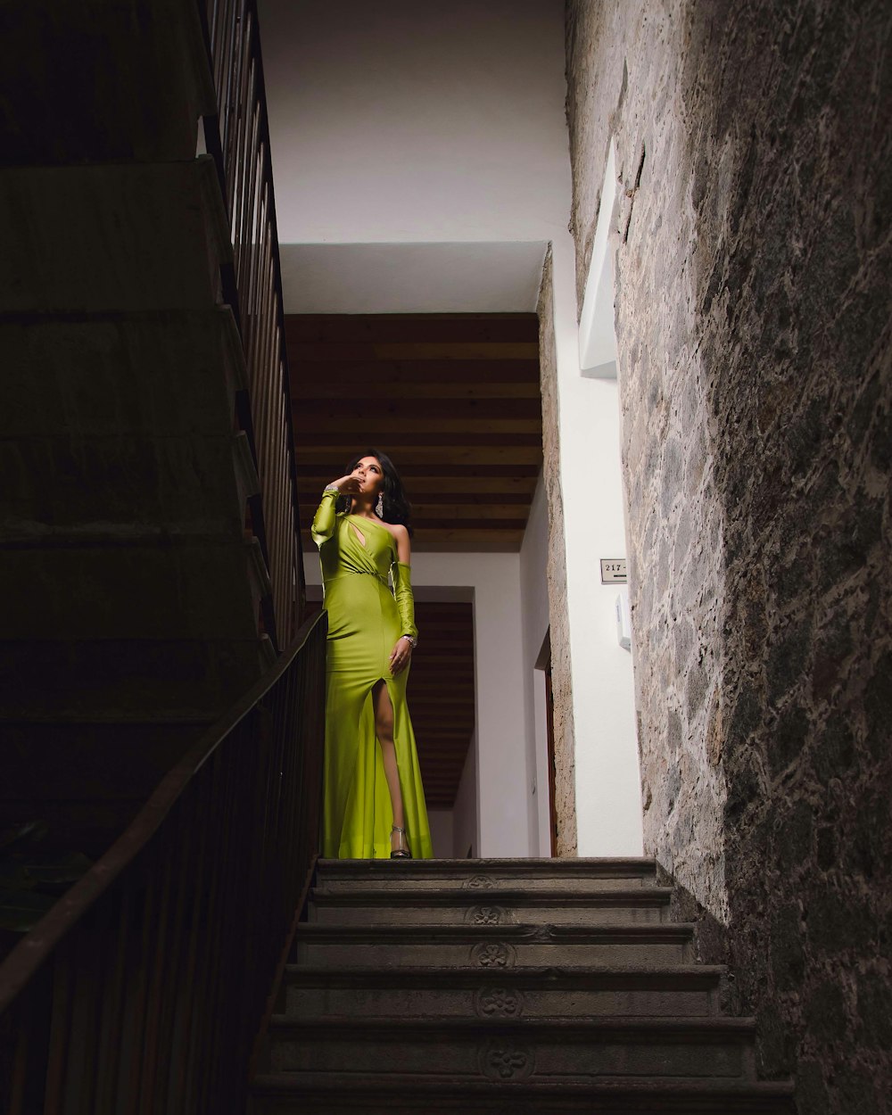 woman in green dress walking down the stairs