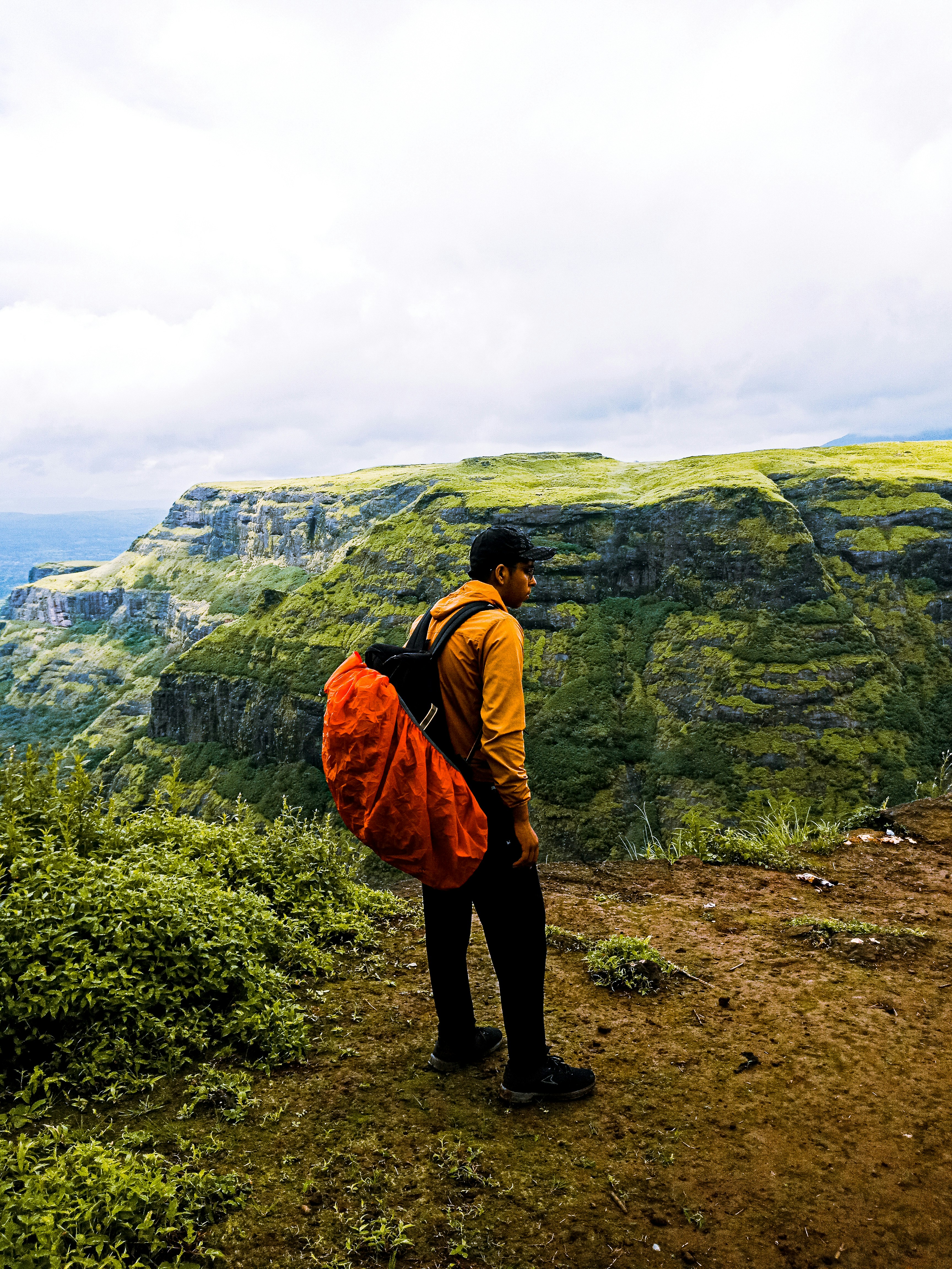 man in brown jacket and black pants standing on brown dirt ground during daytime