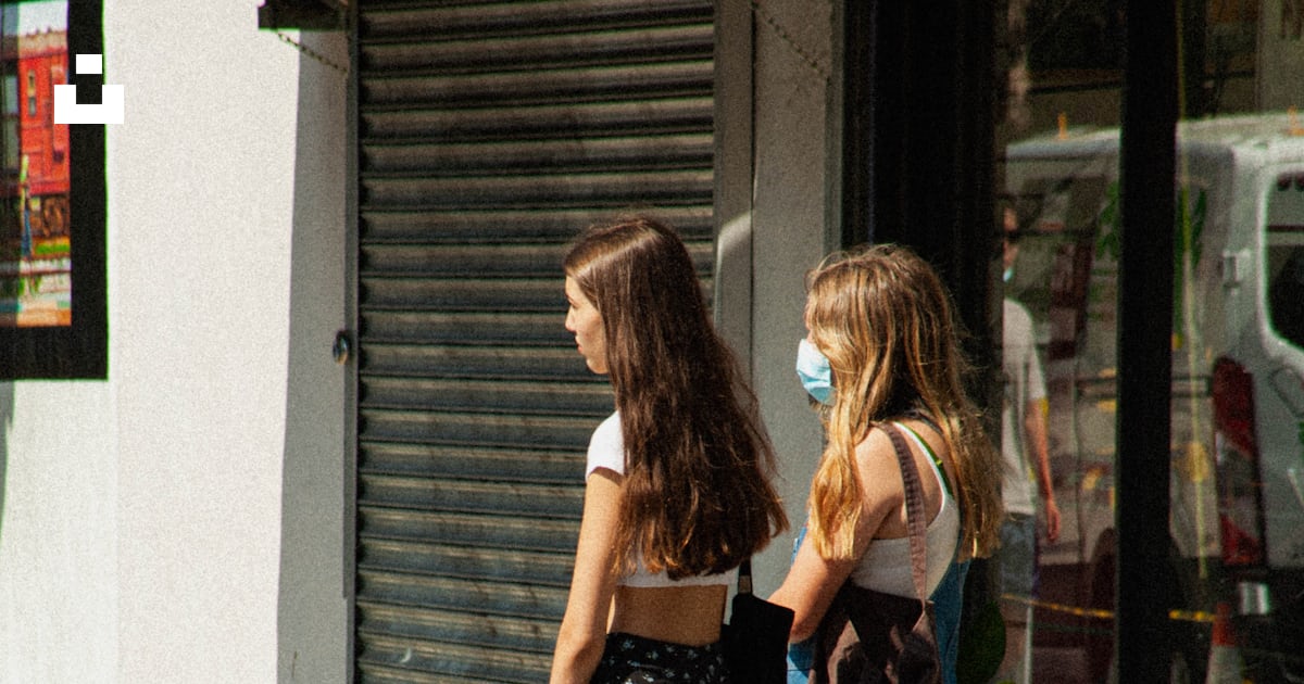 Woman in black tank top and blue denim jeans standing beside woman in ...