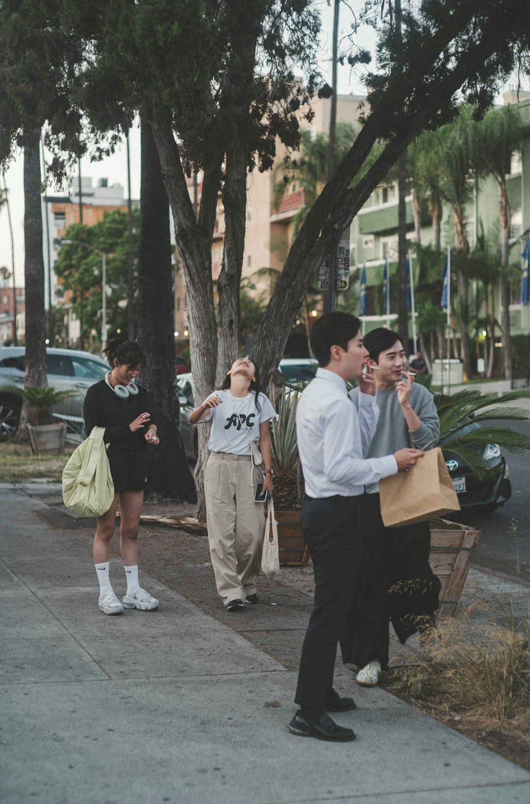 man in white button up shirt and black pants standing beside man in white t-shirt