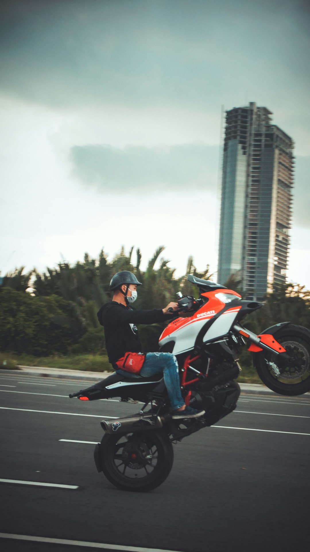 man in black jacket riding orange sports bike on road during daytime