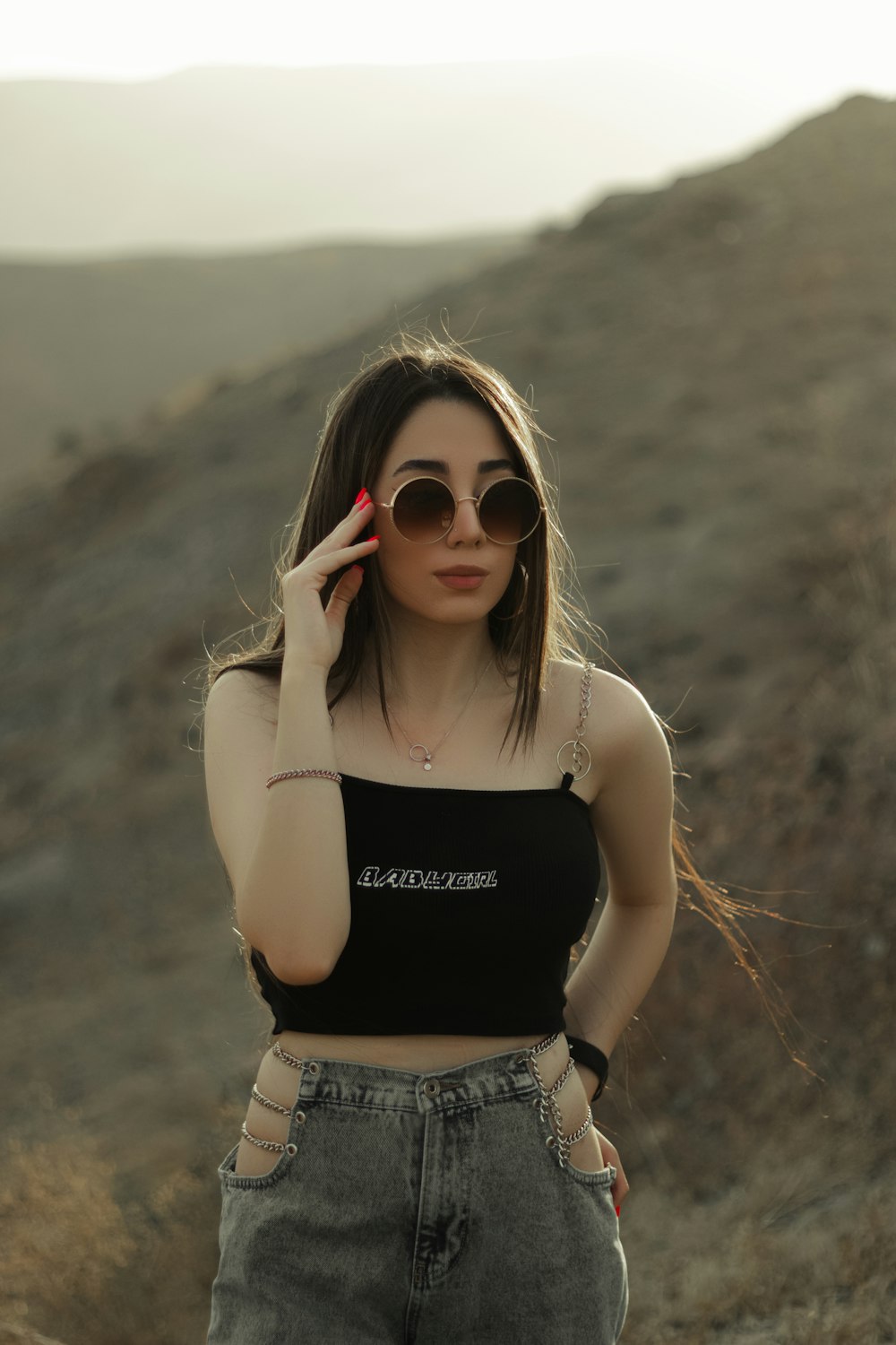 Mujer con camiseta sin mangas negra y gafas de sol marrones