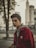 man in red jacket standing near tree during daytime