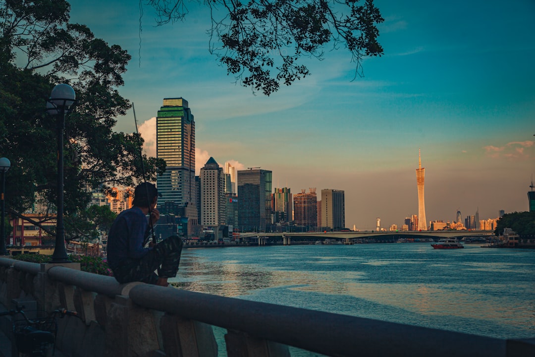 man and woman sitting on concrete bench near body of water during daytime