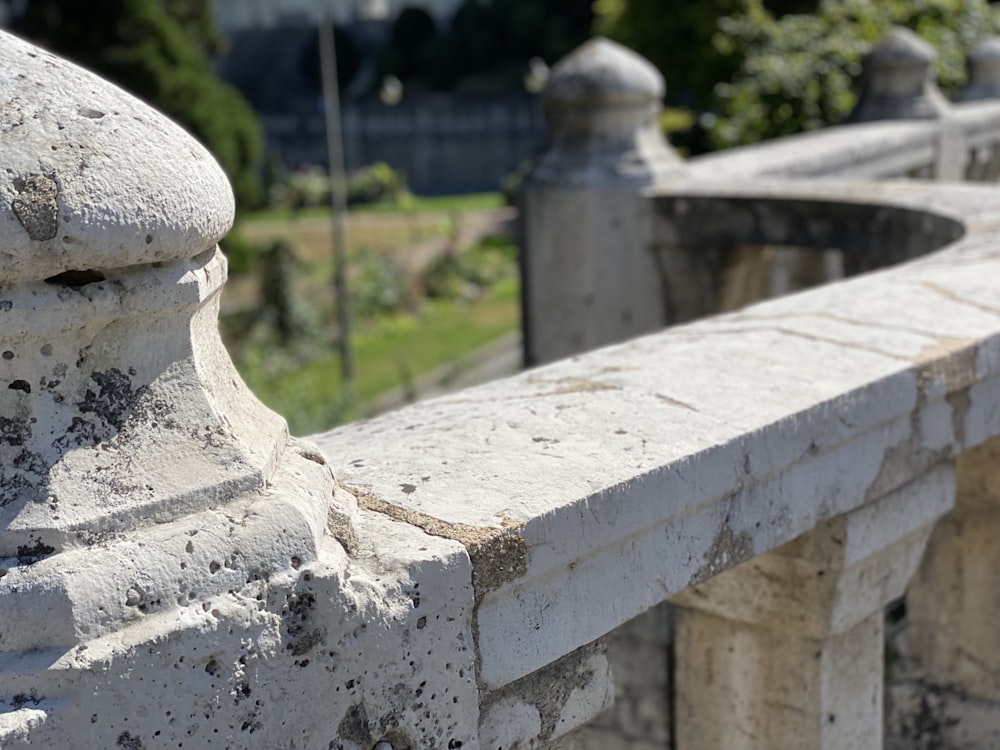 recinzione in cemento bianco vicino al campo di erba verde durante il giorno