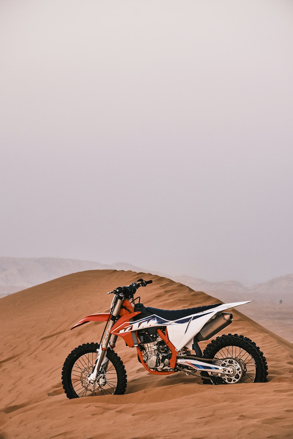 red and black motocross dirt bike on brown sand