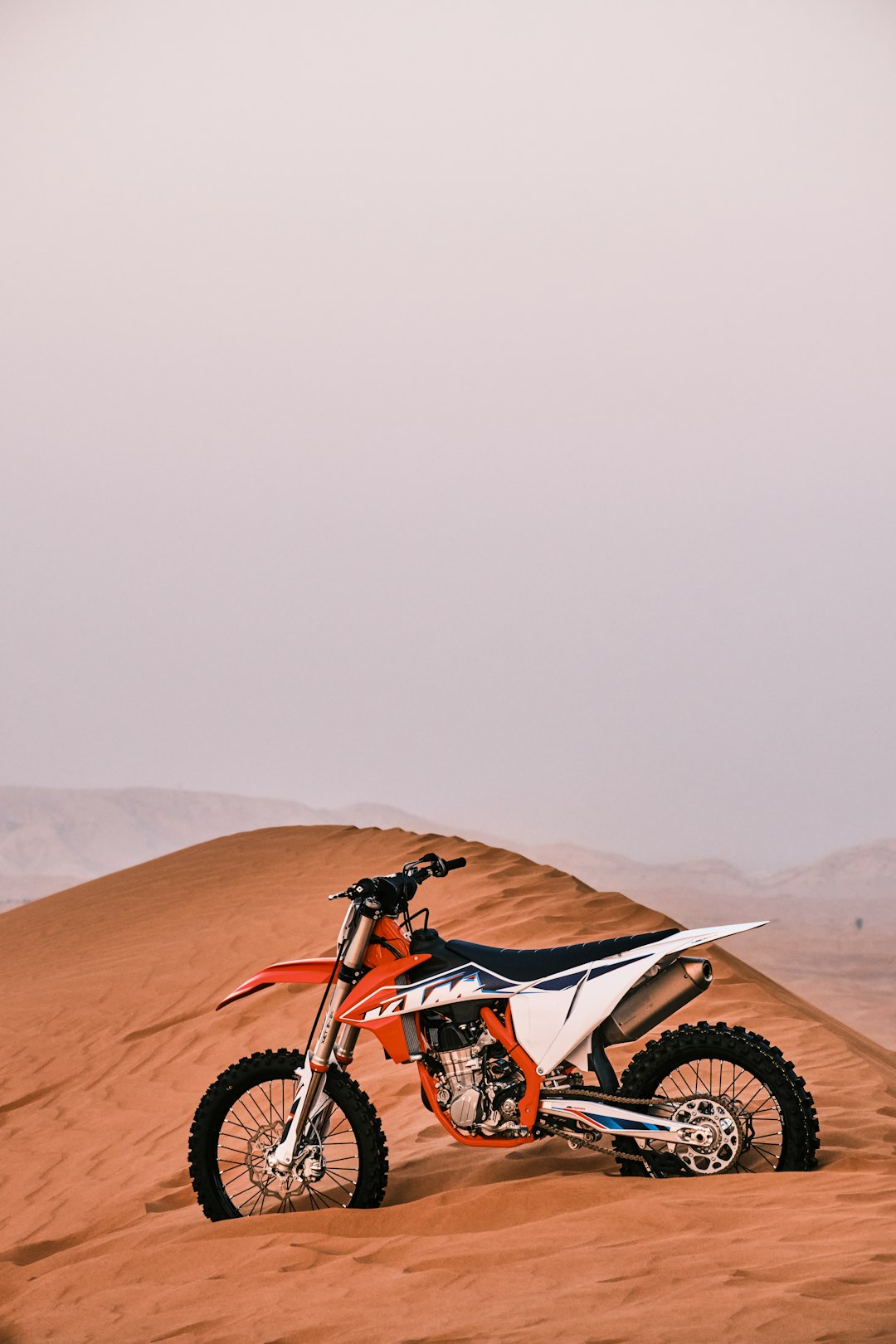 red and black motocross dirt bike on brown sand