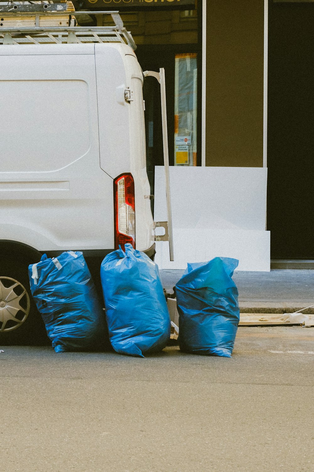 blue plastic bags on gray concrete road