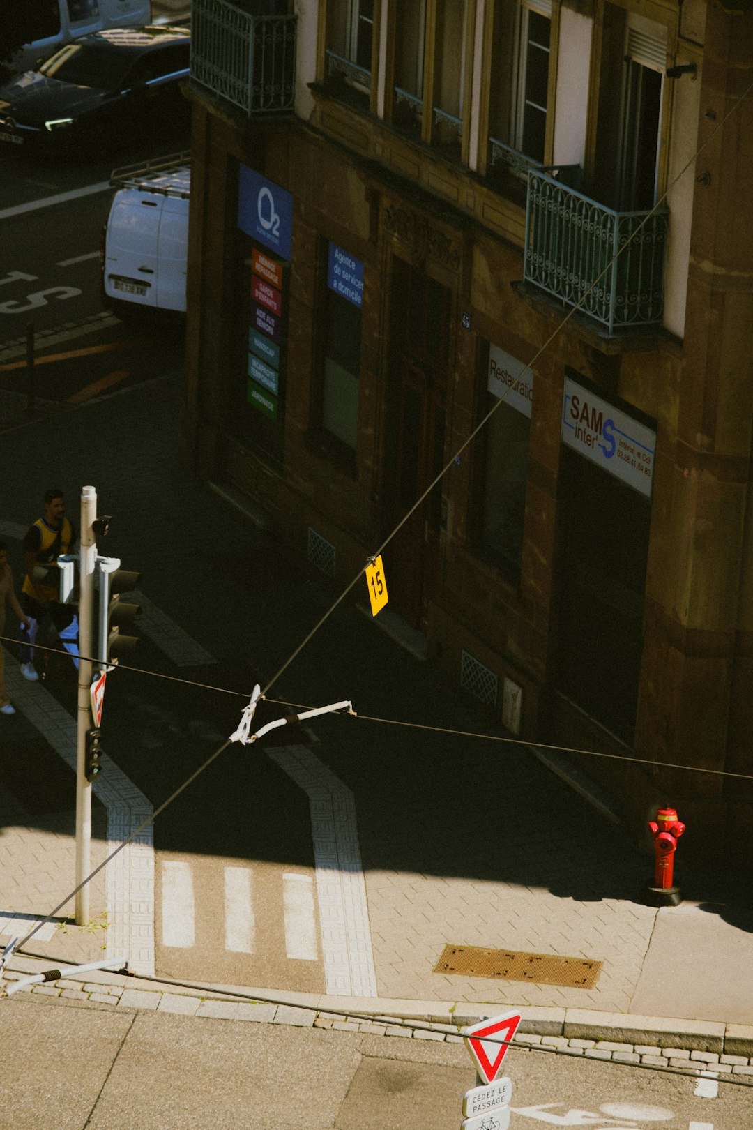 person in red hoodie walking on sidewalk during daytime