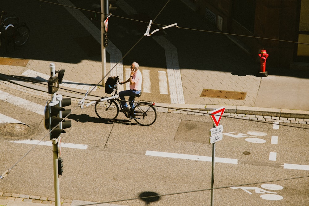 woman in blue shirt riding bicycle on road during daytime