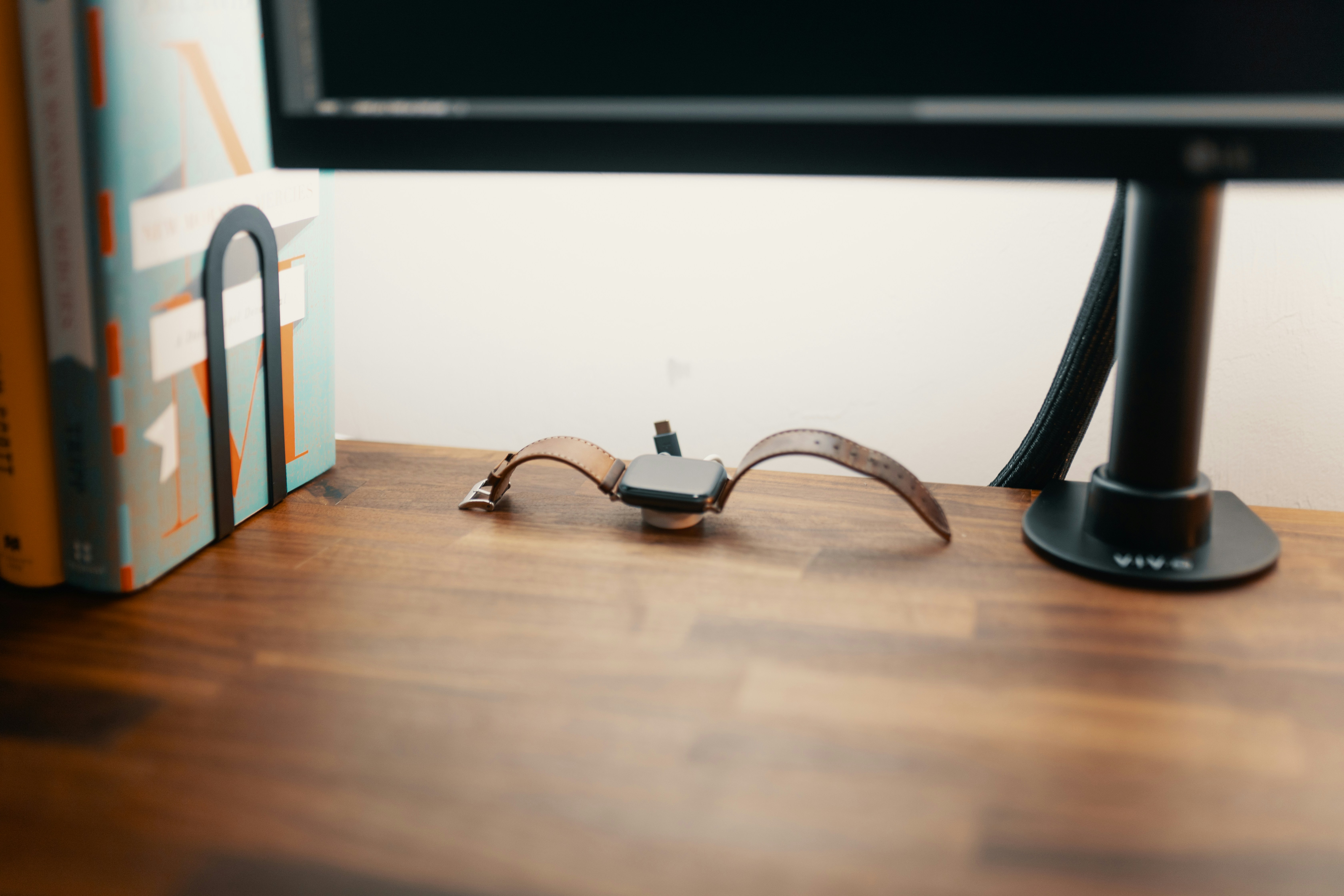 minimalist screenless wearable band sitting on a magnetic aluminum desktop charger