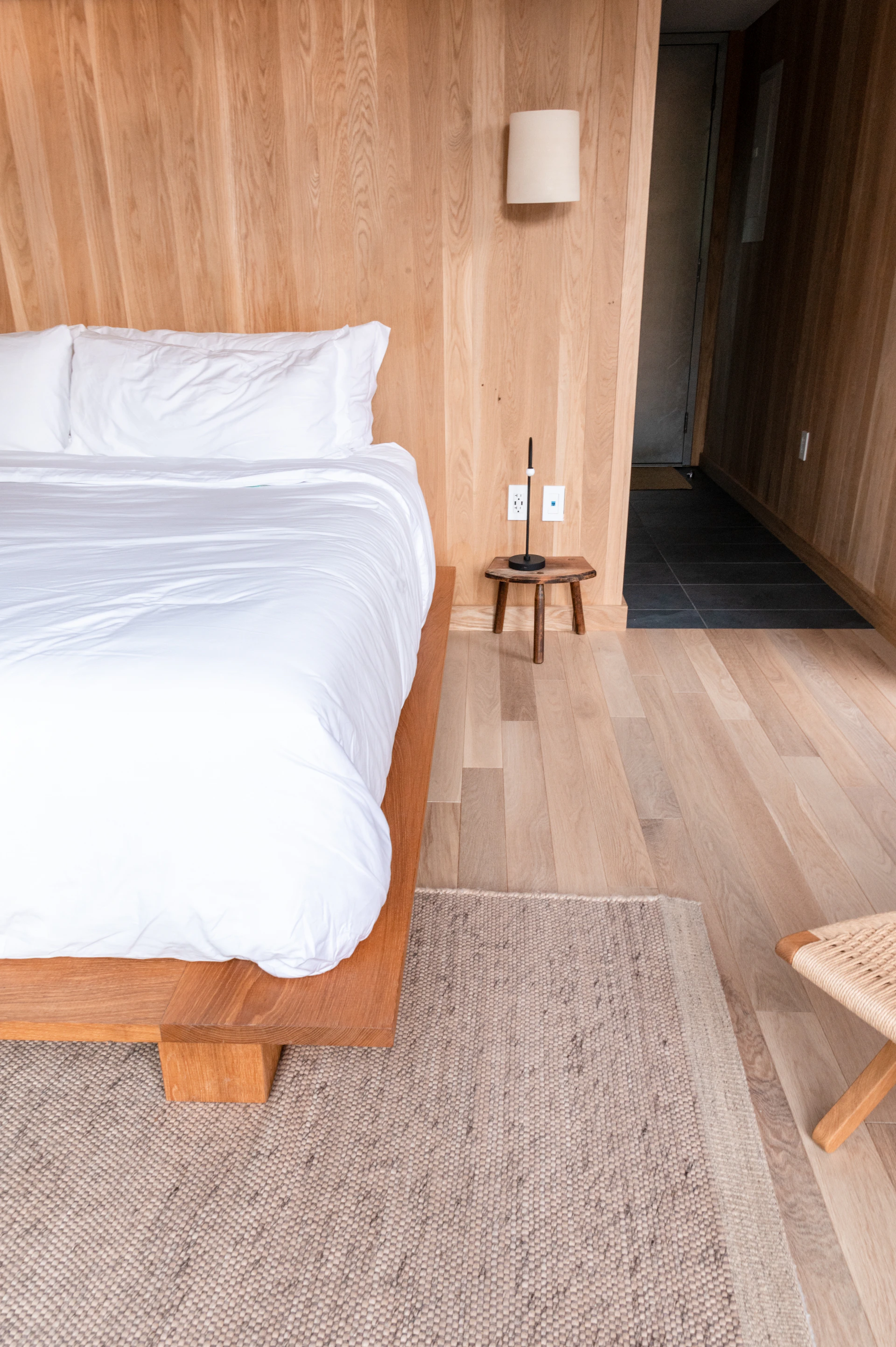 Lit confortable garni de plusieurs oreillers dans une chambre aux tons naturels