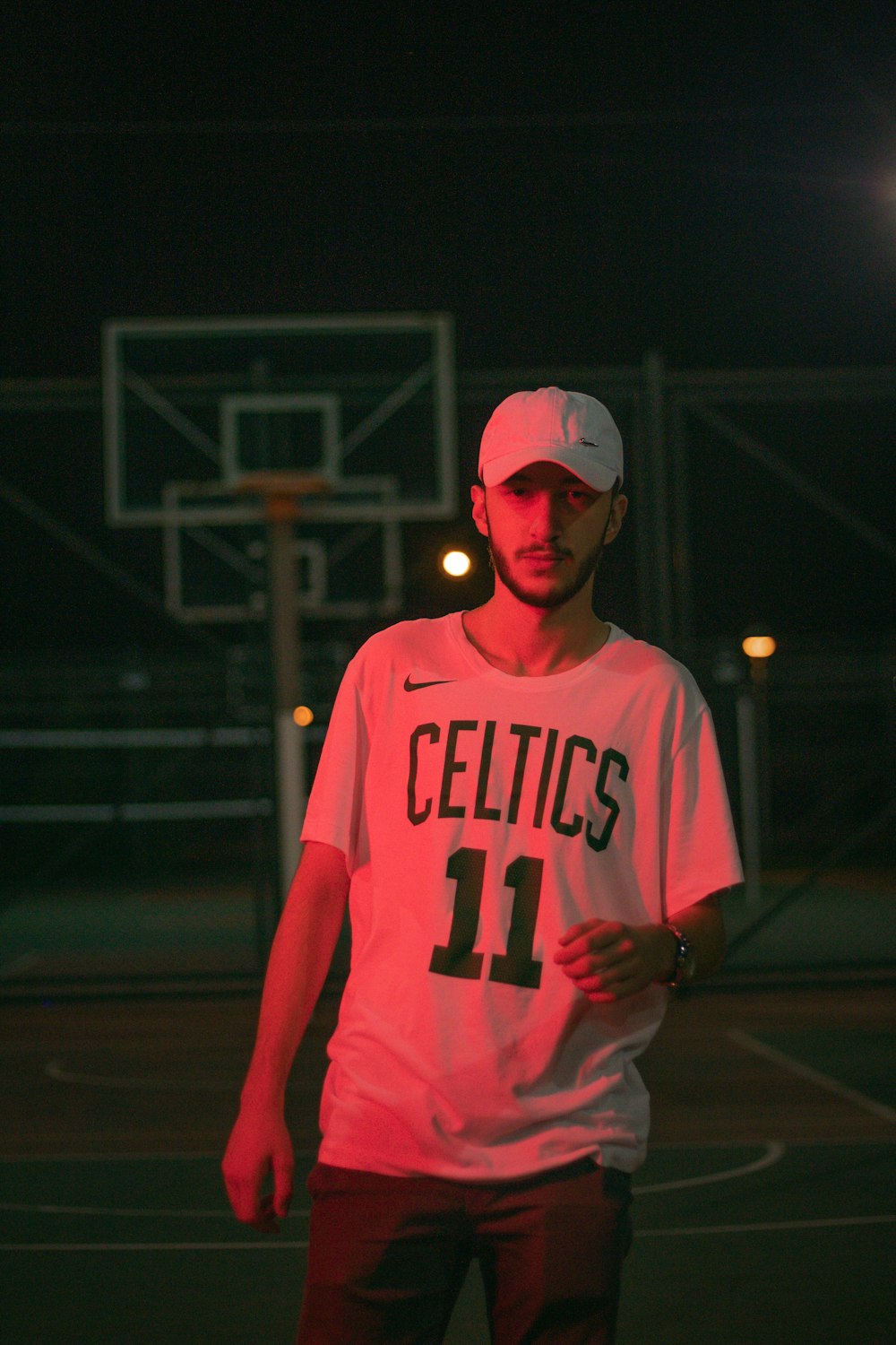 man in pink and white hoodie wearing white cap