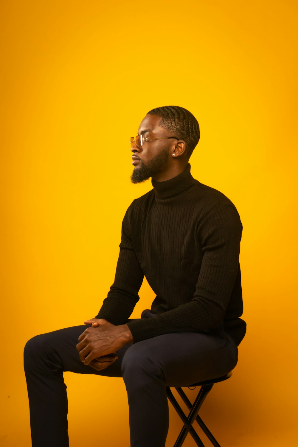 man in black long sleeve shirt sitting on yellow chair