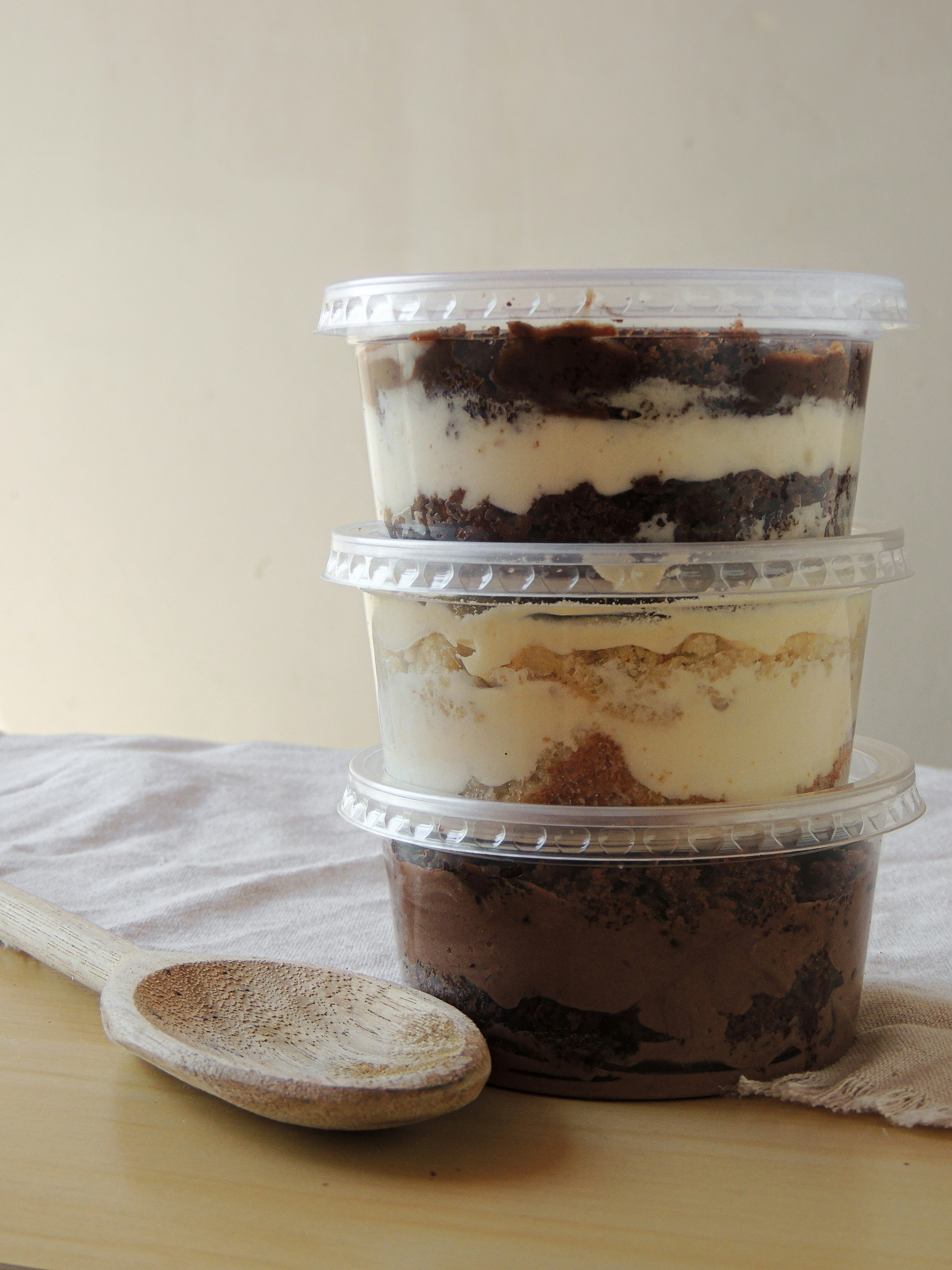 clear glass jar with white cream and brown wooden spoon