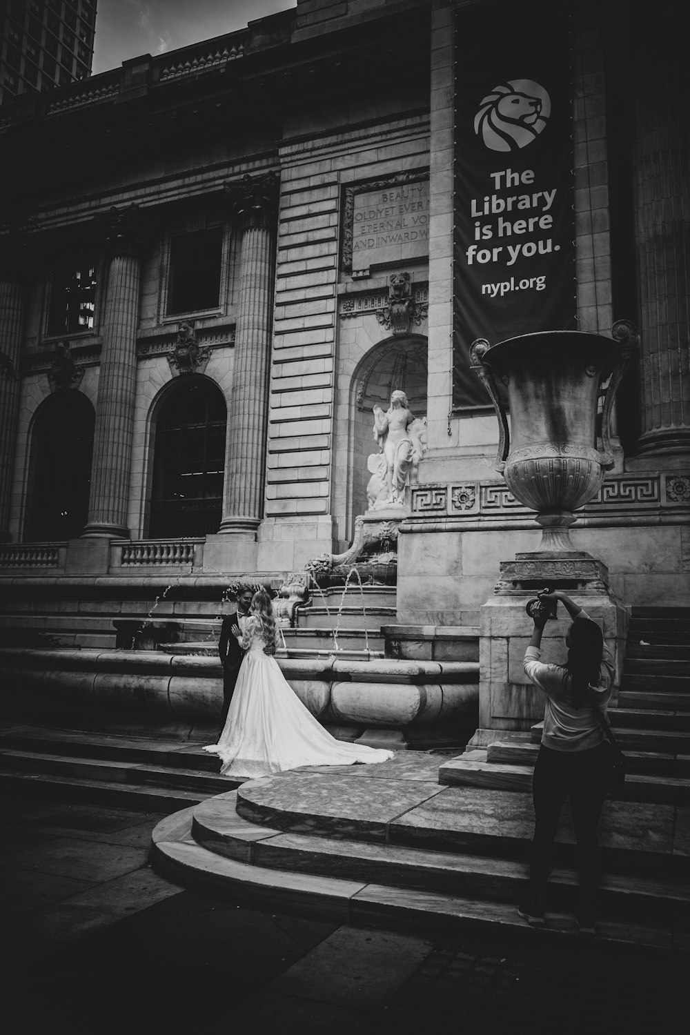 grayscale photo of woman in white dress walking on street