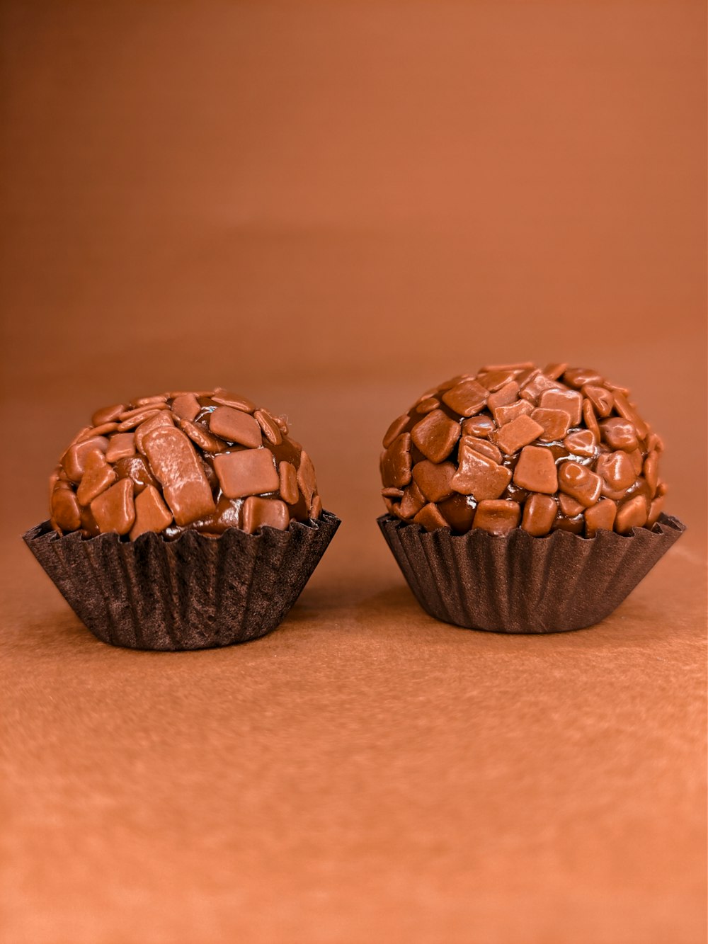 trois cupcakes au chocolat sur une table en bois brun
