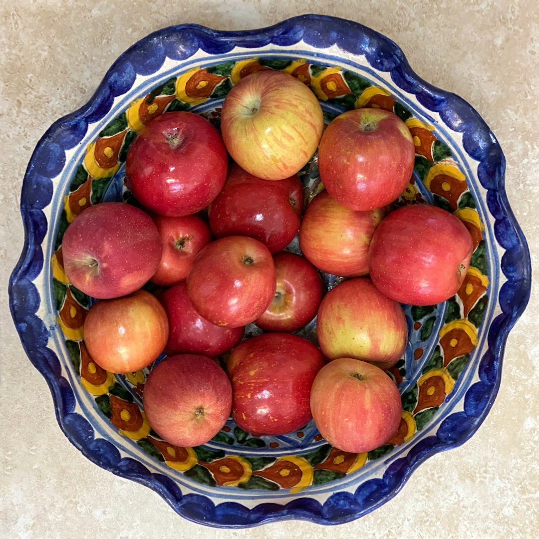 red apples on blue and white floral ceramic bowl