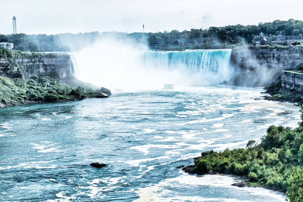 water falls on rocky shore during daytime